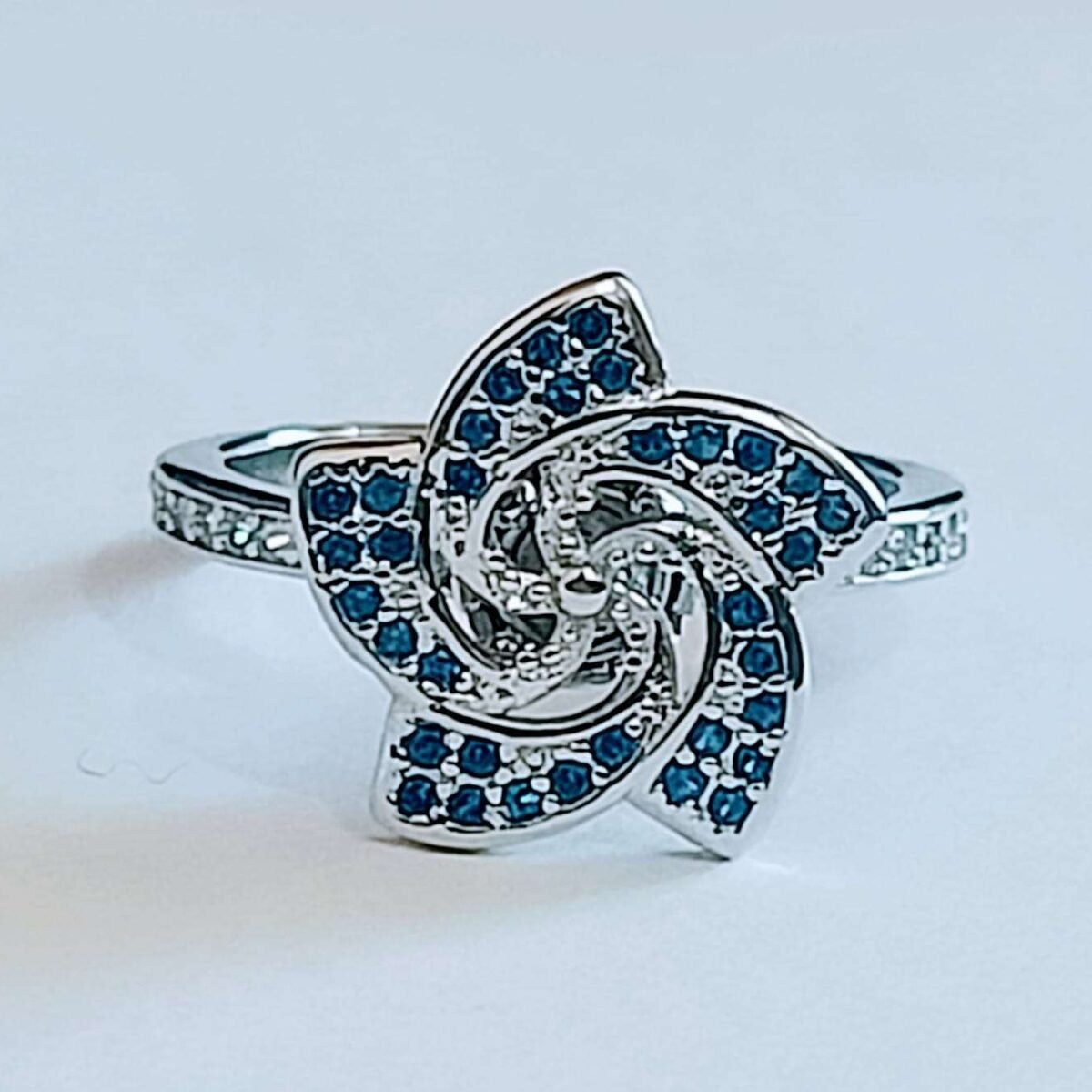 Discover the Elegance of Our Sterling Silver Floral Share Blue Stone Rotating Women's Ring