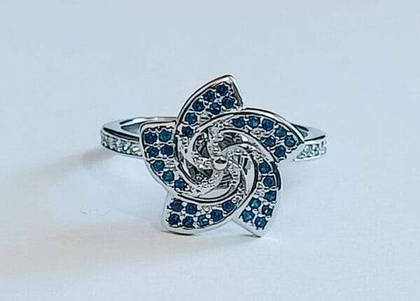 Discover the Elegance of Our Sterling Silver Floral Share Blue Stone Rotating Women's Ring